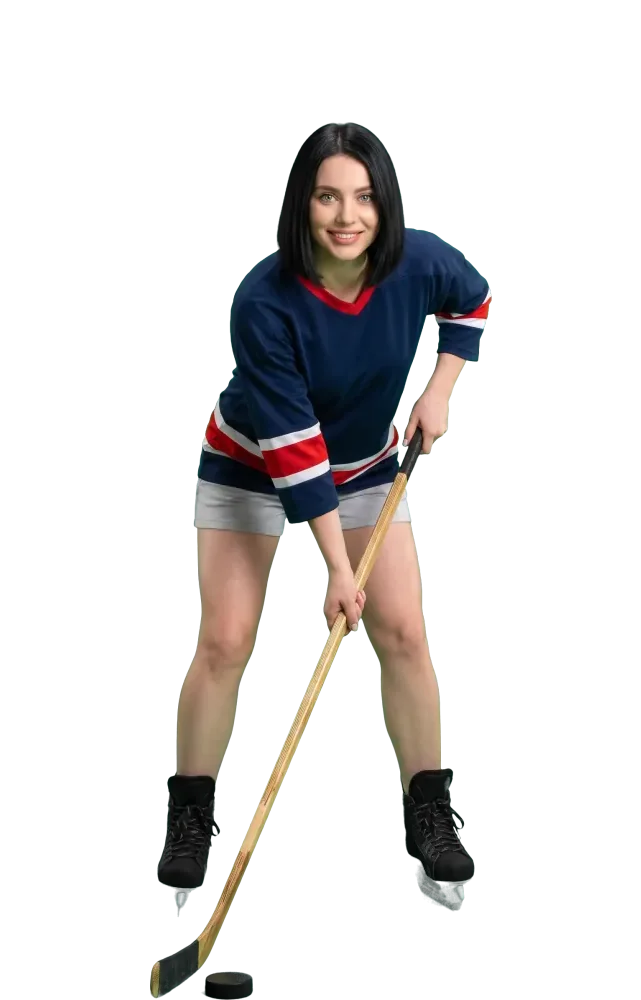 Woman in a hockey ready stance with a puck on her stick
